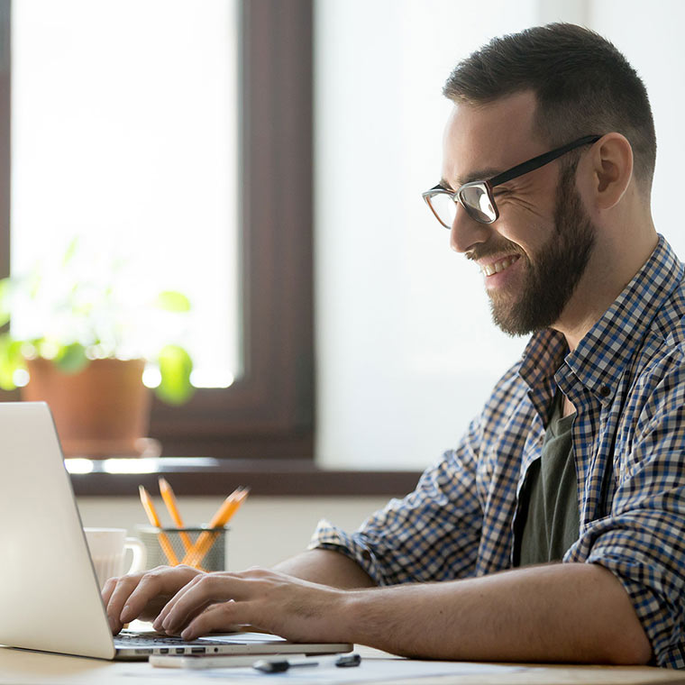 growupitsolution a man sitting at a desk using a laptop